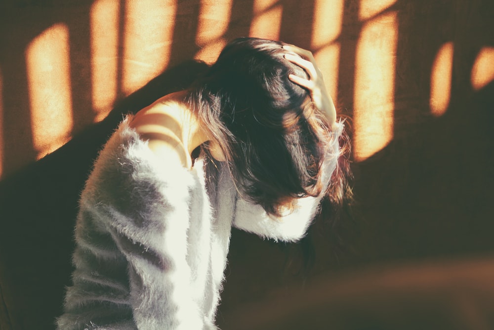 A woman with a headache pressing her head
